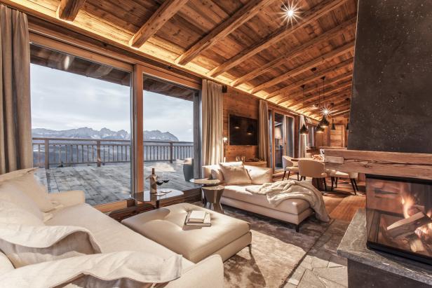 Ein luxuriöses Chalet mit Kamin und Blick auf die schneebedeckten Berge.
