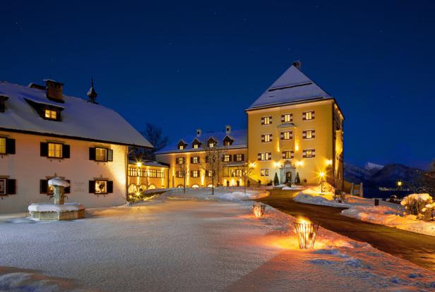 Das Schloss Fuschl im Winter, beleuchtet in der Nacht.