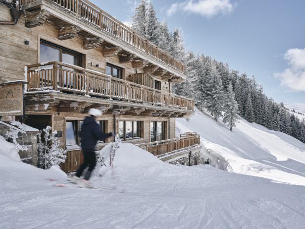 Ein Skifahrer fährt an der Hahnenkamm Lodge in Kitzbühel vorbei.