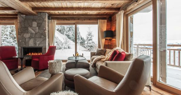 Ein gemütliches Wohnzimmer mit Kamin und Blick auf eine verschneite Landschaft.