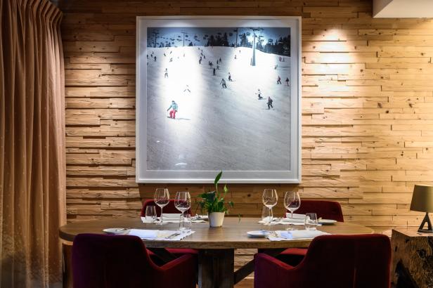 Ein gedeckter Tisch vor einer Holzwand mit einem Bild einer Skipiste.