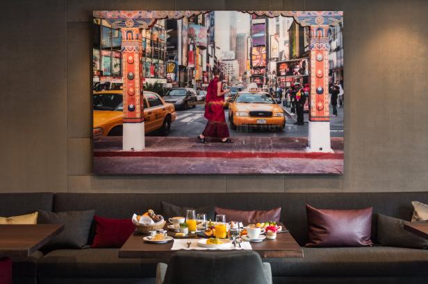 Ein Foto von New York City mit einem buddhistischen Mönch, das über einem Frühstückstisch hängt.
