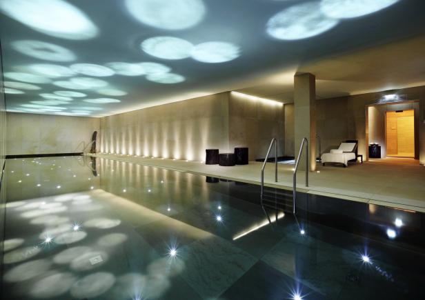 Ein Innenpool mit reflektierenden Lichtern an der Decke und Fliesenboden.