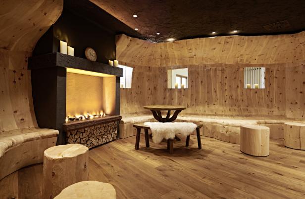 Ein gemütlicher Aufenthaltsraum mit Holzwänden, einem Kamin und rustikalen Möbeln.