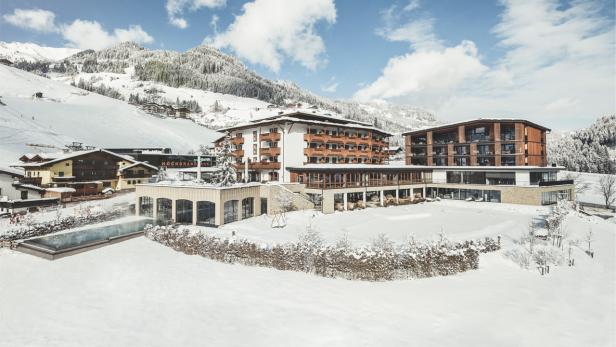 Das Hotel Hochbrand liegt in einer verschneiten Berglandschaft.