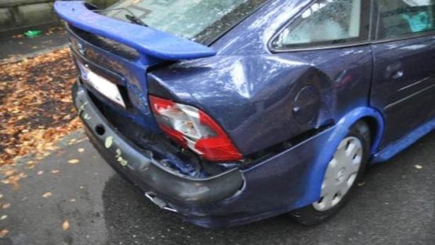 Ein blauer PKW mit Heckschaden am linken Rücklicht und der Stoßstange.