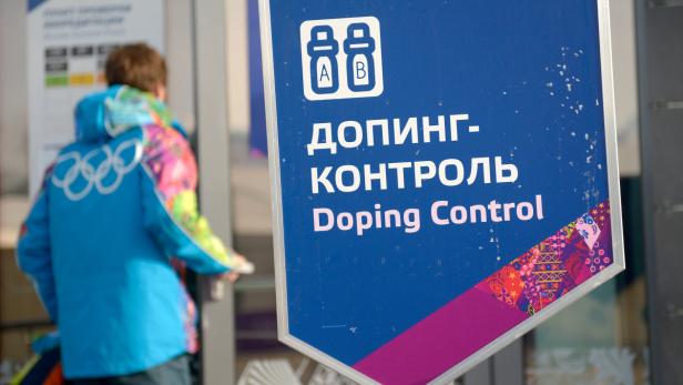 Ein Schild mit der Aufschrift „Doping-Kontrolle“ vor einem Athleten mit Olympia-Symbolen.