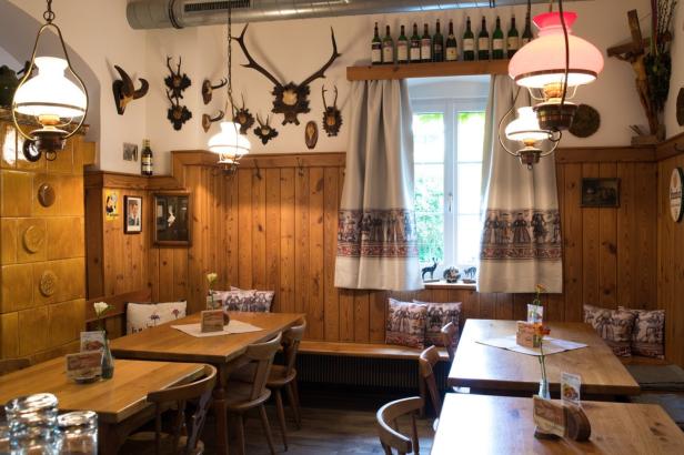 Innenansicht eines traditionellen bayerischen Gasthauses mit Holzvertäfelung und Geweihen an der Wand.