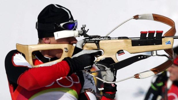 Ein Biathlet zielt mit einem Gewehr der Marke Anschütz.