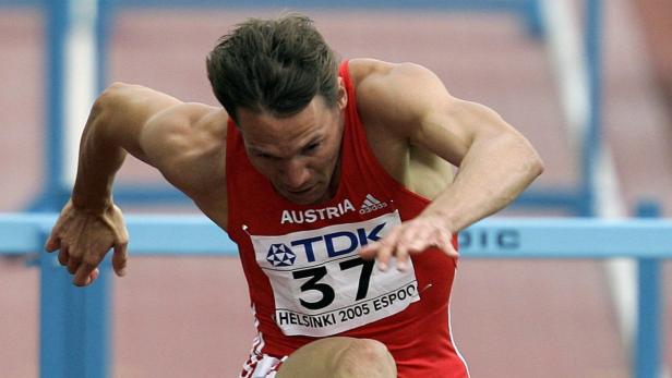 Ein österreichischer Athlet springt bei einem Hürdenlauf.