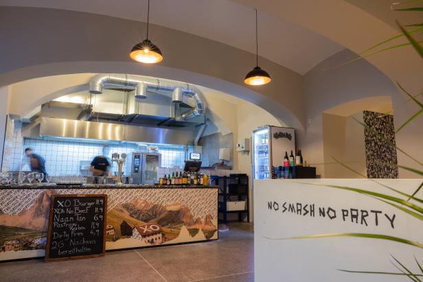 Innenansicht eines Restaurants mit offener Küche und der Aufschrift „No Smash No Party“.