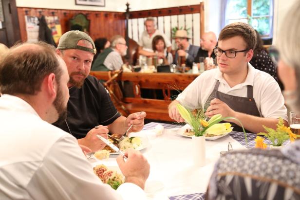 Mehrere Personen sitzen an einem Tisch und essen in einem Restaurant.