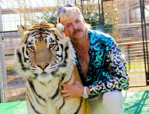 Joe Exotic umarmt einen Tiger.