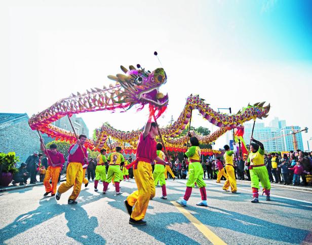 Eine Gruppe von Menschen führt einen traditionellen chinesischen Drachentanz auf der Straße auf.
