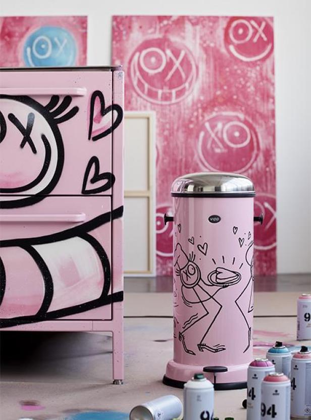 Ein rosa Schrank und ein Mülleimer sind mit Graffiti von André Saraiva verziert.