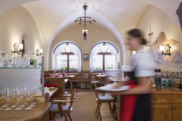 Ein Innenraum des Restaurants Döllerer mit einer Kellnerin im Vordergrund.