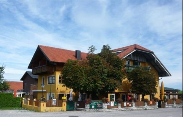 Ein gelbes Gebäude mit rotem Ziegeldach unter blauem Himmel.