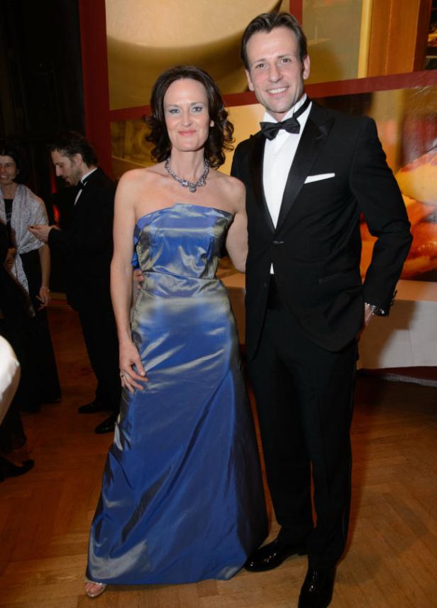 Eine Frau in einem blauen Abendkleid und ein Mann im Smoking posieren für ein Foto.