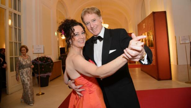 Ein Paar tanzt in festlicher Kleidung auf einem Ball.