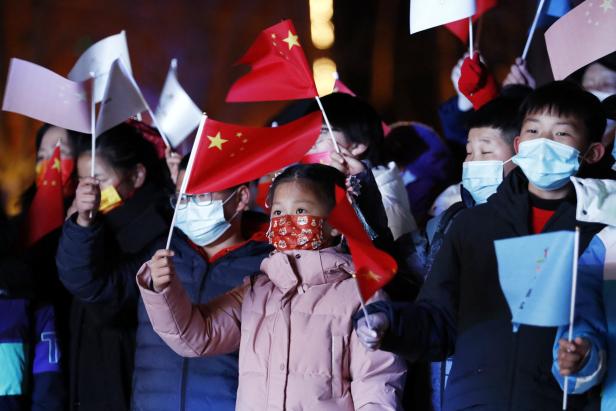 Spectators wave Chinese flags during an event before the Beijing 2022 Winter Olympics opening ceremony, in Beijing