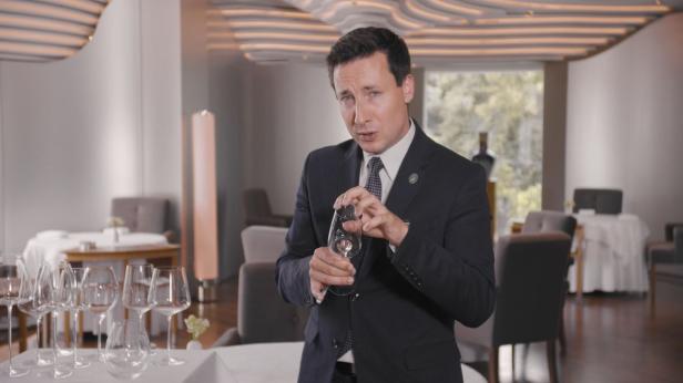 Ein Sommelier in einem Restaurant hält ein Weinglas.