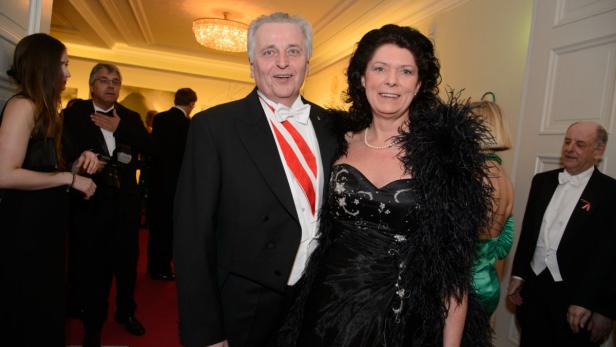 Ein Mann mit einer Schärpe und eine Frau mit einer Federboa posieren für ein Foto.