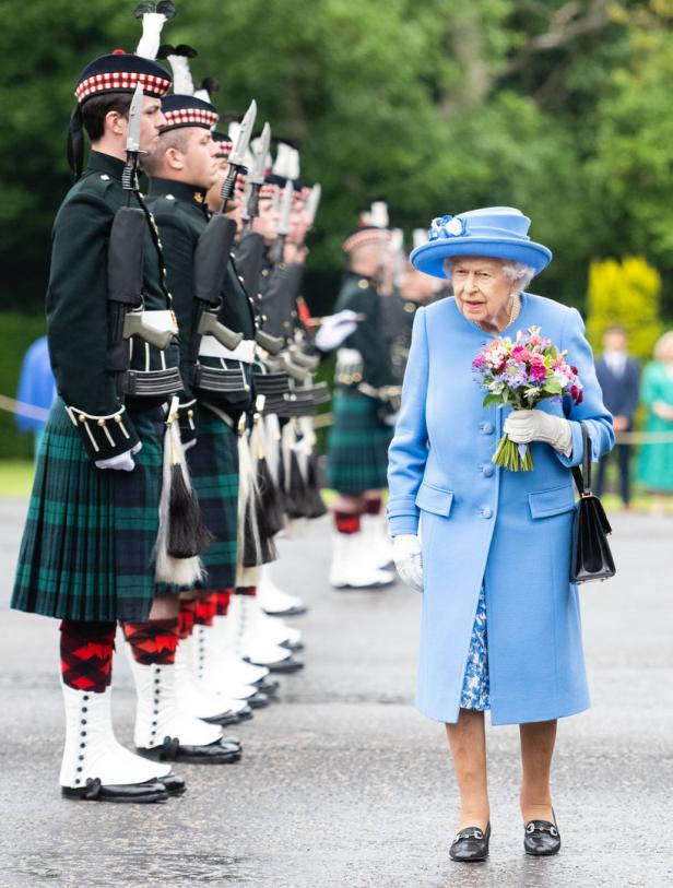 Königin Elizabeth II. schreitet eine Ehrenformation schottischer Soldaten ab.