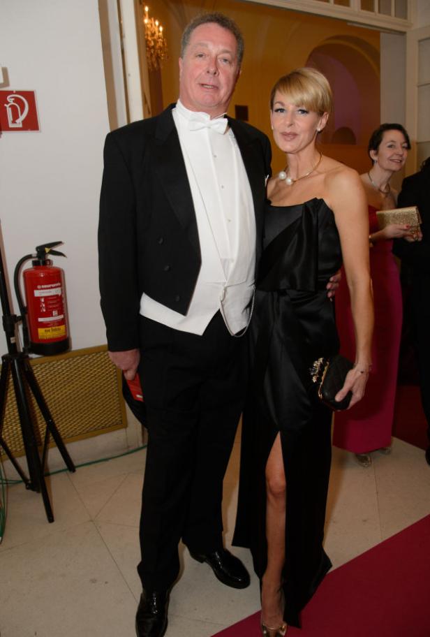 Ein Mann im Frack und eine Frau im Abendkleid posieren für ein Foto.