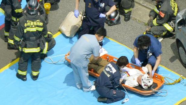 Rettungskräfte versorgen eine verletzte Person auf einer Trage.