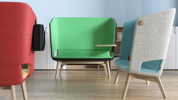 Drei farbige Sessel mit hoher Rückenlehne stehen in einem Raum.