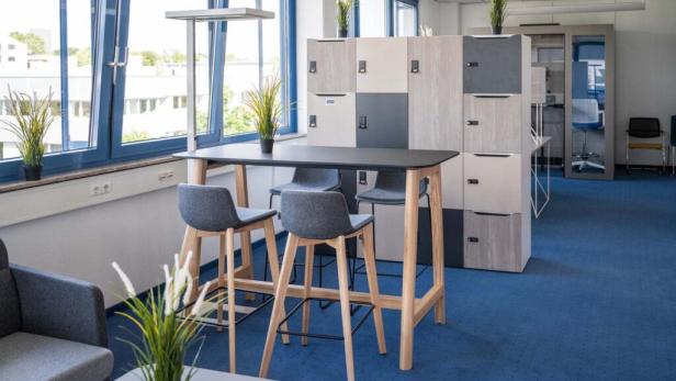 Ein Besprechungstisch mit Barhockern in einem modernen Büro.