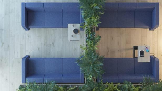 Eine Aufsicht auf blaue Sofas mit Tischen und Pflanzen in einem Büro oder einer Lounge.