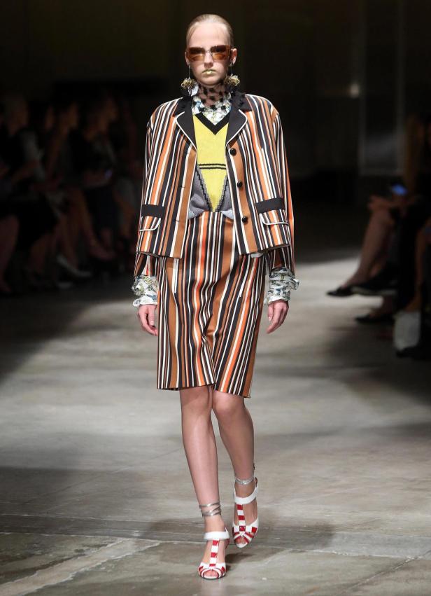 Eine Frau in einem gestreiften Hosenanzug auf einem Laufsteg.