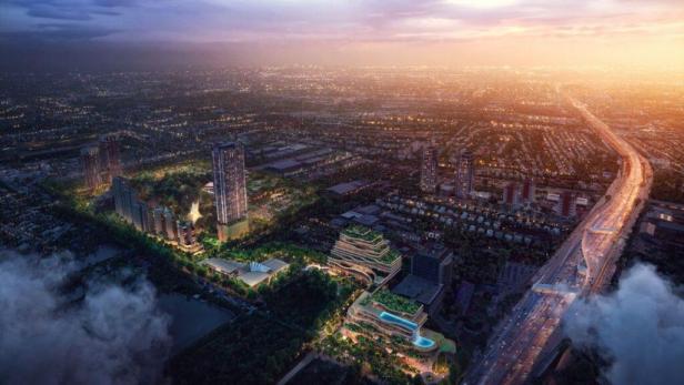 Eine Luftaufnahme einer modernen Stadtlandschaft mit Hochhäusern und einer Autobahn bei Sonnenuntergang.