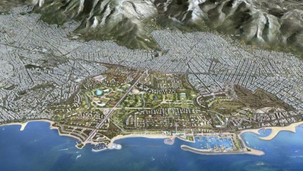 Eine Luftaufnahme des Küstenortes Hellinikon mit Bergen im Hintergrund.