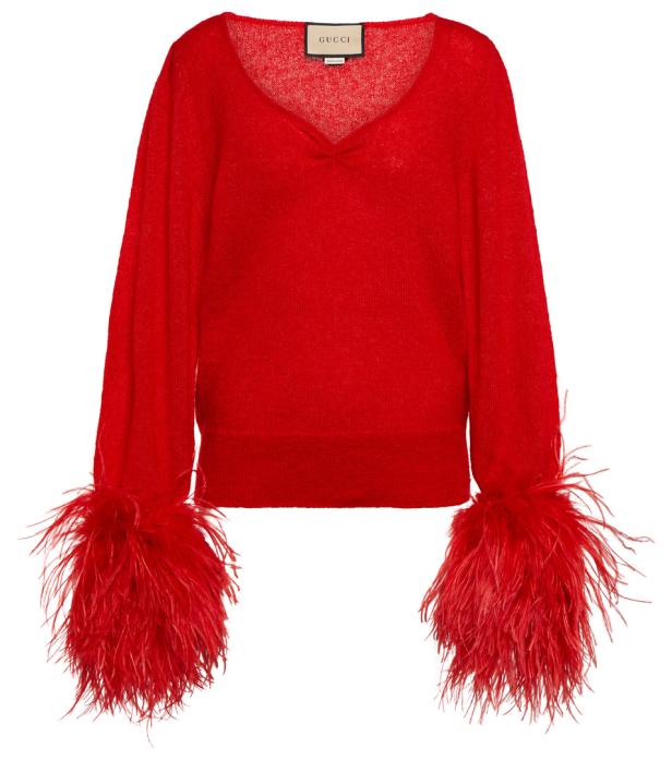 Ein roter Pullover von Gucci mit Federn an den Ärmeln.