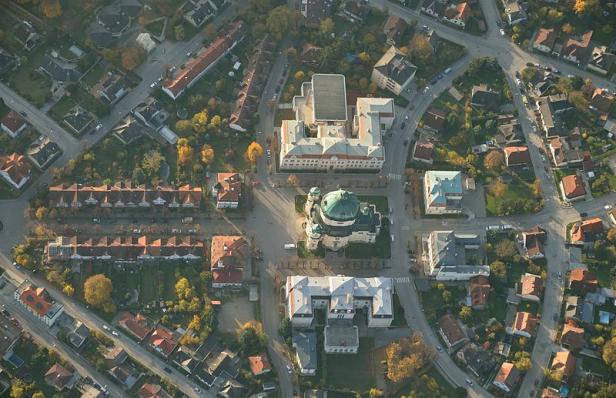 Luftaufnahme einer Stadt mit einer Kirche mit grüner Kuppel im Zentrum.