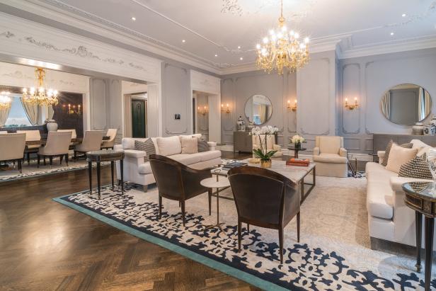 Ein elegantes Wohnzimmer mit hellgrauen Wänden und einem großen Kristalllüster.