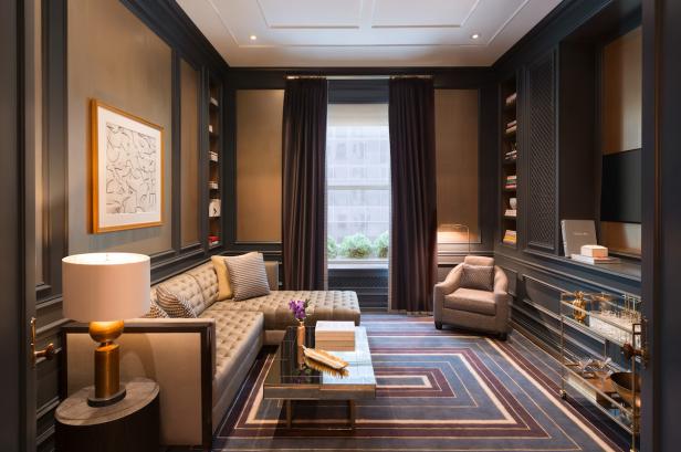 Ein elegant eingerichtetes Wohnzimmer mit Sofa, Sessel und Bücherregalen.