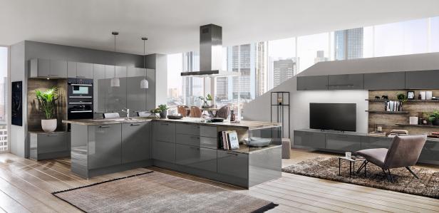 Eine moderne, graue Küche mit Kochinsel und Blick auf eine urbane Skyline.