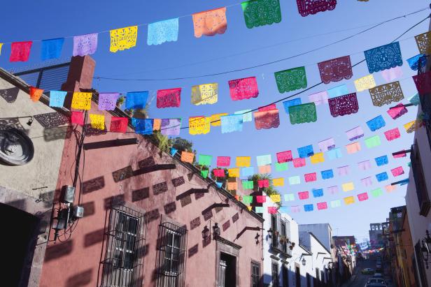 Bunte Papel Picado Girlanden schmücken eine Straße in einer mexikanischen Stadt.