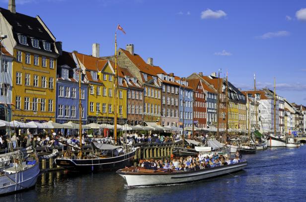 Der Nyhavn Kanal in Kopenhagen mit bunten Häusern und Ausflugsbooten.
