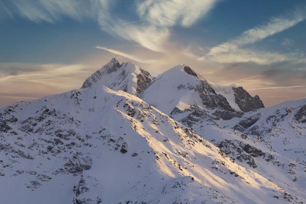 Verschneite Berggipfel ragen in den Himmel.