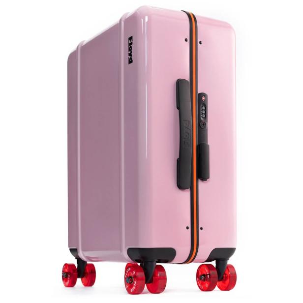 Ein rosa Rollkoffer der Marke Floyd mit roten Rollen.