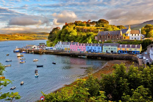Blick auf Tobermory, Schottland, mit bunten Häusern am Wasser und Booten im Hafen.