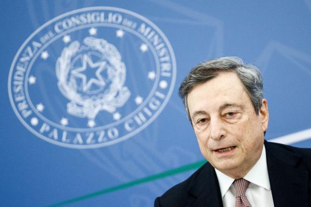 Mario Draghi vor einem blauen Hintergrund mit dem Logo des Palazzo Chigi.
