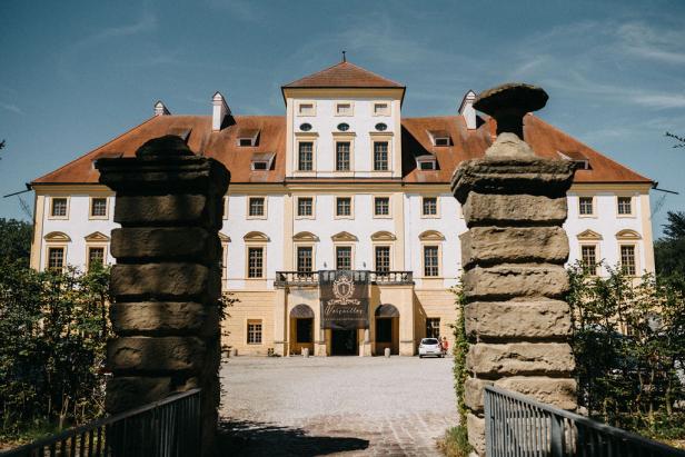 Das Schloss Versailles in Erbach wird durch ein steinernes Tor gezeigt.
