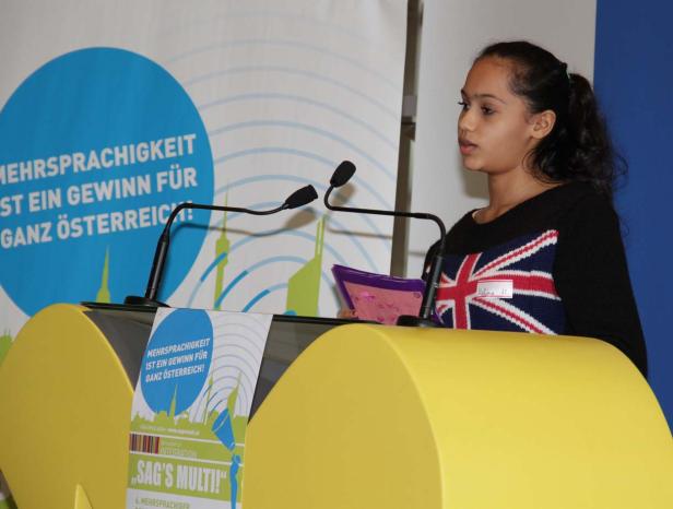Ein junges Mädchen hält eine Rede auf einer Veranstaltung zum Thema Mehrsprachigkeit.