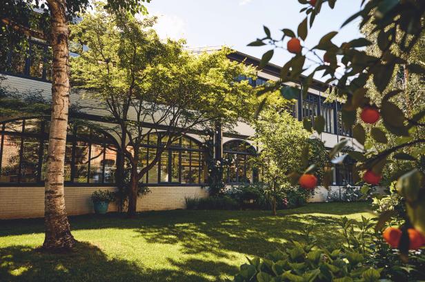 Die Manufaktur von Louis Vuitton, umgeben von einem grünen Garten.