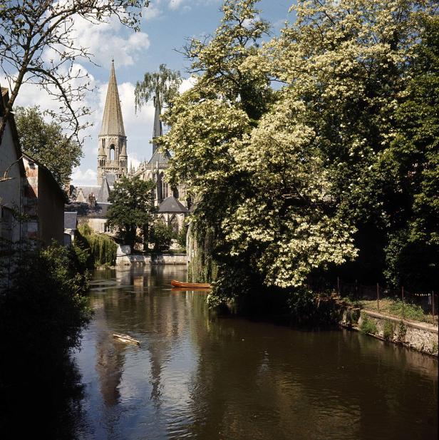 Ein Kanal mit einem kleinen Boot führt zu einer gotischen Kirche.